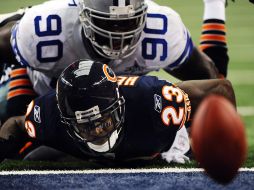 El jugador de los Osos de Chicago, Devin Hester (abajo) es derribado por Jay Ratliff (arriba) de los Vaqueros de Dallas. EFE  /