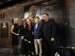 Miembros de la famila de George Steinbrenner' posan ante la estatua del ex dueño de los Yankees. REUTERS  /