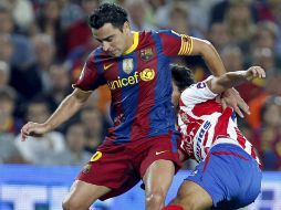 El centrocampista del FC Barcelona, Xavier Hernández (izq) protege el balón ante el centrocampista del Sporting, Miguel Ángel. EFE  /