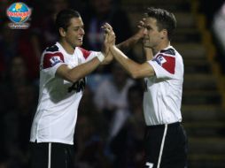 Javier 'Chicharito' Hernández (izq.) festeja la victoria junto a Michael Owen. AP  /