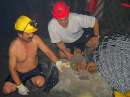 Trabajadores inspeccionan una pieza de taladro que cayó en donde los obreros se encuentran atrapados. AP  /