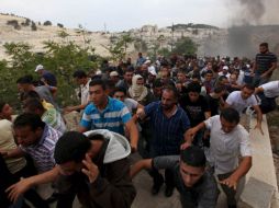 Hombres palestinos buscan refugio durante unos enfrentamientos con la Policía israelí antidisturbios. EFE  /