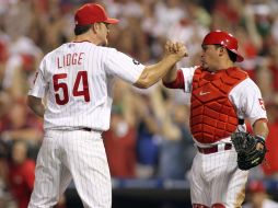 Carlos Ruiz (izq) festeja con el lanzador Brad Lidge el triunfo ante los Mets. EFE  /