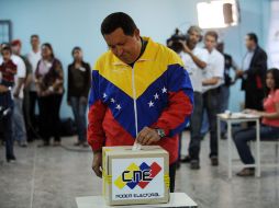 El presidente venezolano Hugo Chávez deposita su voto en la urna. AFP  /