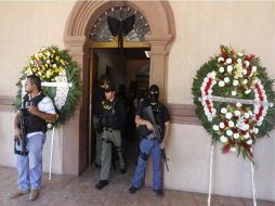 Detectives de la Policía montan guardia junto a coronas de flores para el alcalde Prisciliano Rodríguez. REUTERS  /