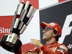 Fernando Alonso con el trofeo que recibe tras ganar en Singapur. EFE  /