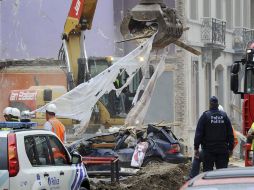 Una máquina remueve escombros tras la explosión que dejó 17 heridos, en un barrio de Bruselas. AP  /