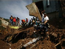 Unos hombres inspeccionan vivivendas dañadas en Santa María de Tlahuitoltepec. AP  /