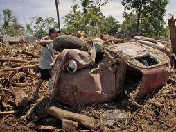 Un hombre busca sus pertenencias debajo de un auto, donde antes solía estar su casa en Amatán, Chiapas. EL UNIVERSAL  /