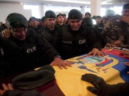 Miembros de la Policía de élite ecuatoriana escoltan a sus colegas caídos tras el asalto para liberar al presidente Rafael Correa. AFP  /