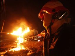 Bomberos de Pakistán tratan de extinguir el fuego después de que un convoy ataco a 25 camiones con combustible. EFE  /