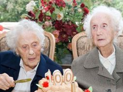 Las gemelas Marie Hendrix (izq) y Gabrielle Vaudremer cortan el pastel de su cumpleaños número cien. AFP  /