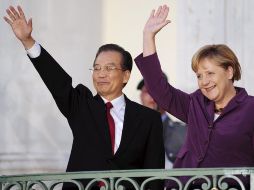 Angela Merkel (der.) y el primer ministro chino, Wen Jiabao (izq.), saludan desde un balcón del castillo de Meseberg, Alemania. EFE  /
