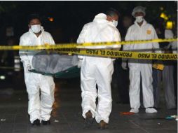 Personal forense lleva el cuerpo de una mujer asesinada a tiros en una plaza comercial en el centro de Monterrey. REUTERS  /