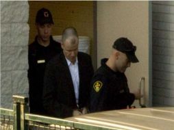 Coronel Russell Williams es escoltado por la policía fuera de la corte en Belleville, Ontario. AP  /