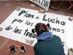 Un joven pinta un cartel en una carpa de trabajadores del Estado. EFE  /