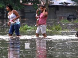 Dos mujeres caminan por las calles inundadas de la colonia Cuencas, ubicada en el municipio de Medellín, Veracruz. EL UNIVERSAL  /