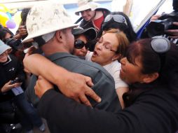Familiares abrazan al operador de una de las máquinas que participó en las excavaciones para llegar a los mineros. AFP  /
