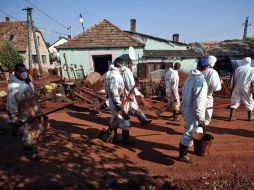 Rescatistas se preparan para comenzar la limpieza de las propiedades que sufrieron menos daños por el derrame tóxico en Hungría. AFP  /