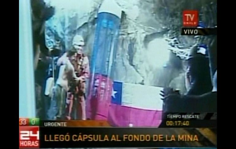 Imagen de video que muestra al rescatista Manuel González (segundo izq.), que es recibido por los mineros atrapados. AP  /