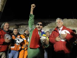 Luis Urzúa (verde) celebra su salida junto al presidente Sebastián Piñera (der.). EFE  /