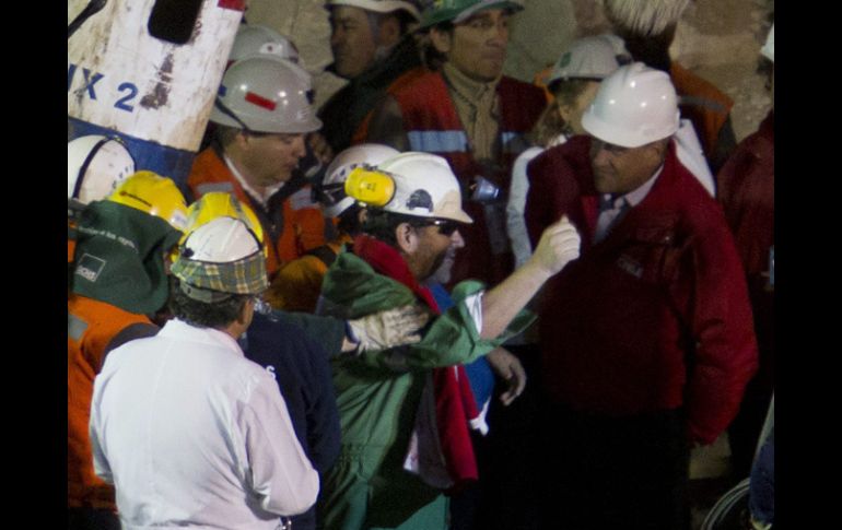 Luis Urzúa (centro) tras salir hoy de la mina San José. AFP  /