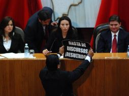 El diputado panista Ernesto Alfonso Robledo muestra al gobernador de Nuevo León, Rodrigo Medina, un cartel de protesta. EL UNIVERSAL  /