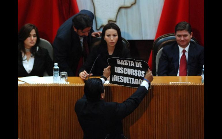 El diputado panista Ernesto Alfonso Robledo muestra al gobernador de Nuevo León, Rodrigo Medina, un cartel de protesta. EL UNIVERSAL  /