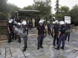 Policías antidisturbios vigilan la entrada al recinto arqueológico de la Acrópolis. EFE  /