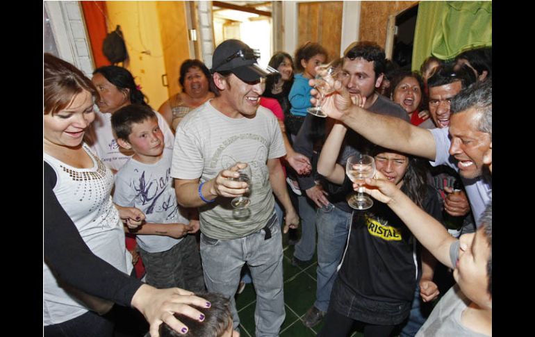 Ariel Ticona (centro, con gorra) brinda con familiares y amigos a su llegada a su casa, tras ser dado de alta. REUTERS  /