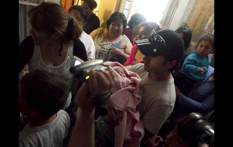 El minero Ariel Ticona sostiene a su hija Esperanza, quien nació mientras él estaba atrapado en la mina San José. EFE  /