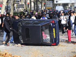 Manifestantes destrozan un coche en el Centro de Lión en Francia, durante la protesta contra la reforma de pensiones, en Francia. EFE  /