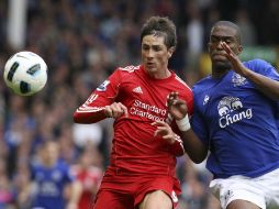 El delantero español del Liverpool, Fernando Torres (izq.), pelea por el balón con el jugador del Everton, Sylvain Distin. EFE  /