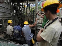 Mineros se adentran a la mina donde quedaran atrapados cuatro de sus compañeros la madrugada del viernes. AFP  /