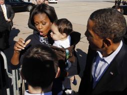 La primera dama estadounidense, Michelle Obama, reacciona cuando un niño deja caer su mamila mientras su esposo sonríe. REUTERS  /