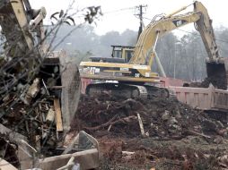 Una máquina excavadora retira los restos de una vivienda totalmente destrozada en Kolontár. EFE  /