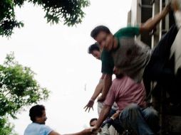 Una mujer entrega varias raciones de comida a los inmigrantes centroamericanos abordo de los ferrocarriles. EFE  /