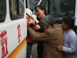 Familiares y amigos de un minero que murió llegan a la mina en la ciudad de Yuzhou, en la provincia de Henan. AP  /