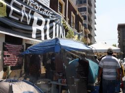 Las casas de campaña junto a decenas de pancartas que se encuentran a las afueras del número 111 de la calle Pavo. A. HINOJOSA  /