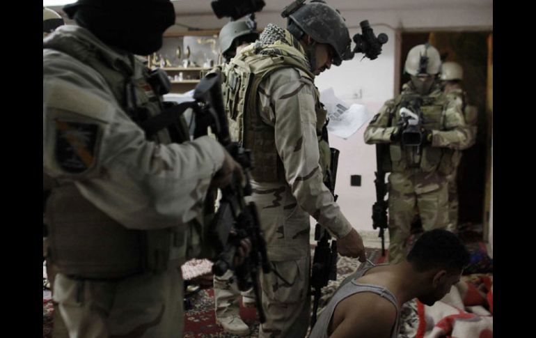 Un hombre es interrogado por un comando de operaciones especiales iraquíes, mientras que un camarógrafo graba la escena. AFP  /