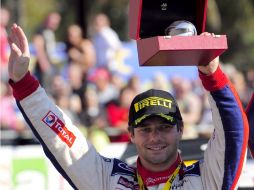 El piloto francés Sebastien Loeb festeja su triunfo levantando su trofeo de el Rally de Cataluña. AFP  /