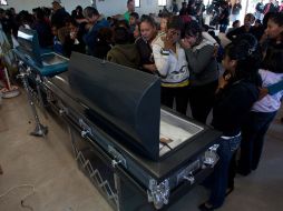 Hombres entran a la Iglesia con el féretro de una de las víctimas de la masacre. AP  /