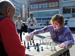 Una mujer disfrazada de zombi juega ajedrez con un hombre en Nueva York. AFP  /
