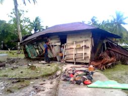 Una familia revisa su casa tras ser arrastrada por olas de tres metros, en Pagai Utara, una de las Islas Mentawai. AFP  /
