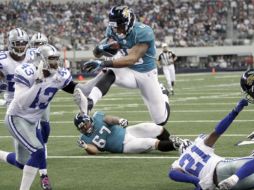 Mike Thomas (c) anota ante la defensiva de los Vaqueros de Dallas. AP  /