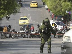 Un experto en explosivos acude hoy a detonar un paquete sospechoso afuera de una empresa de mensajería en Atenas. REUTERS  /