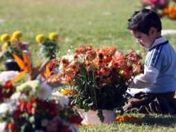 Un pequeño recuerda a sus seres queridos en el panteón Recinto de la Paz. A.HINOJOSA  /
