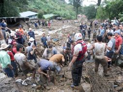 En la zona del deslave, los pobladores no cesan los trabajos de rescate de vítimas. AFP  /