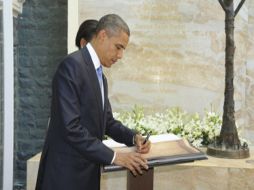 Obama firmando en el libro de visitas, durante su homenaje a las víctimas del atentado múltiple de 2008. EFE  /