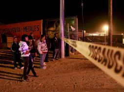 En Ciudad Juárez, un grupo de jóvenes observa desde la zona precintada el lugar donde siete jóvenes fueron asesinados ayer. EFE  /
